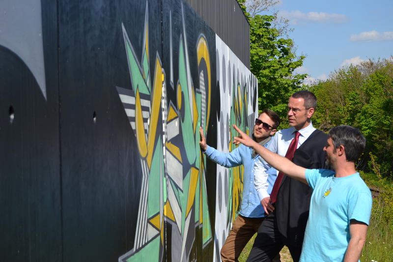 Till Heim, B&uuml;rgermeister Dr. Maximilian Ingenthron und Uli Roth (v.r.n.l.) pr&auml;sentieren die neuen Graffitis an der Br&uuml;cke S&uuml;d