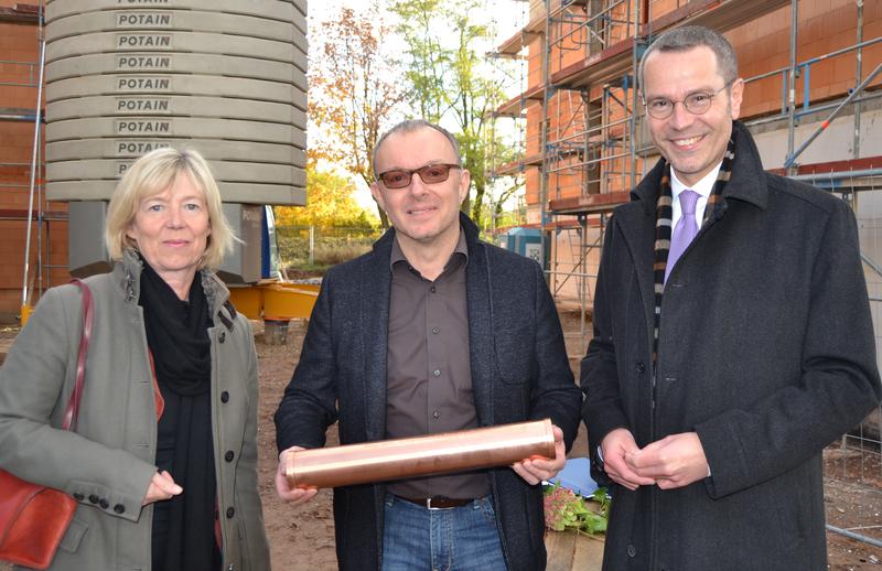 Ministerin Ahnen und B&uuml;rgermeister Dr. Ingenthron &uuml;berreichten eine Zeitkapsel an einen Vertreter der Baugruppe &raquo;Im Wohnpark Am Ebenberg&laquo;. Auch die Baugruppe &raquo;Passiv-/Plusenergieh&auml;user&laquo; wurden mit einer Zeitkapsel bedacht.
