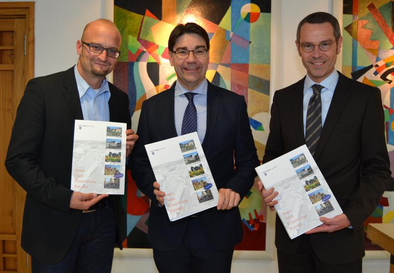 Oberb&uuml;rgermeister Thomas Hirsch (Mitte), B&uuml;rgermeister Dr. Maximilian Ingenthron (rechts) und Bauamtsleiter Christoph Kamplade mit dem Innenstadtentwicklungskonzept.