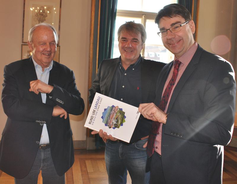 Oberb&uuml;rgermeister Thomas Hirsch (r.) gemeinsam mit Verleger Markus Knecht und dessen Mitarbeiter G&uuml;nter Haas (l.) bei der Vorstellung des zweiten Bildbandes im Empfangssaal des Landauer Rathauses.
