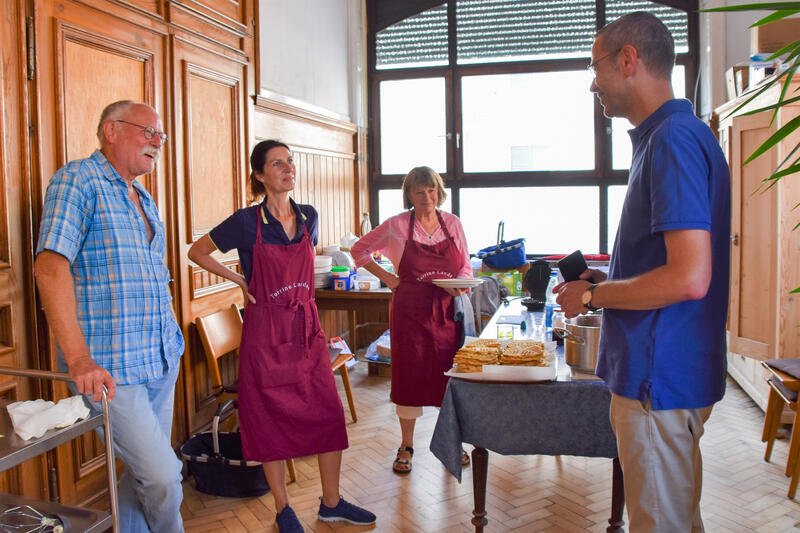 B&uuml;rgermeister Dr. Maximilian Ingenthron (l.) bei seinem Terrine-Besuch im Gespr&auml;ch mit Vereinsvorsitzendem Artur Hackert (r.) und zwei ehrenamtlichen Kochteam-Mitarbeiterinnen.