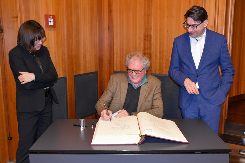 Der diesj&auml;hrige Preistr&auml;ger Til Mette (M.) trug sich im Beisein von OB Thomas Hirsch (r.) und Stadtarchivarin sowie Thomas-Nast-Vereinsvorsitzenden Christine Kohl-Langer ins goldene Buch der Stadt Landau ein. 