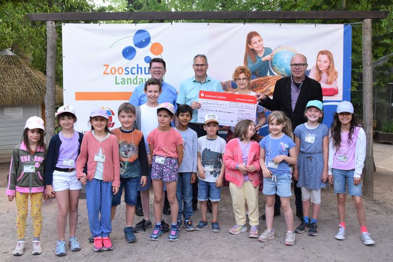 Der Vorsitzende der Sparkasse S&uuml;dpfalz Bernd Jung, Landrat Dietmar Seefeldt (S&Uuml;W), Zooschulleiterin Dr. Gudrun Hollstein und Oberb&uuml;rgermeister Dr. Dominik Gei&szlig;ler (LD) bei der Spenden&uuml;bergabe (hintere Reihe v.l.n.r.) mit einigen Kindern der Zooschule.