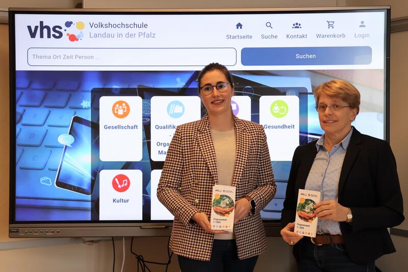 Die Leiterin der VHS Landau Sigrid Gensheimer und Dezernentin Lena D&uuml;rphold (links) mit dem Programm zum Fr&uuml;hjahrsemester 2024.