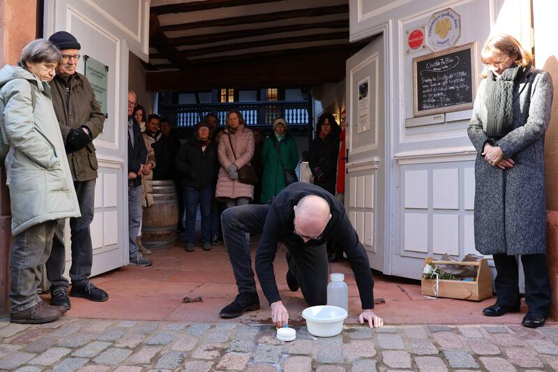 Landaus Oberb&uuml;rgermeister Dominik Gei&szlig;ler beim S&auml;ubern des Stolpersteins von Olga Loeb vor dem Frank-Loebschen Haus in Landau. 