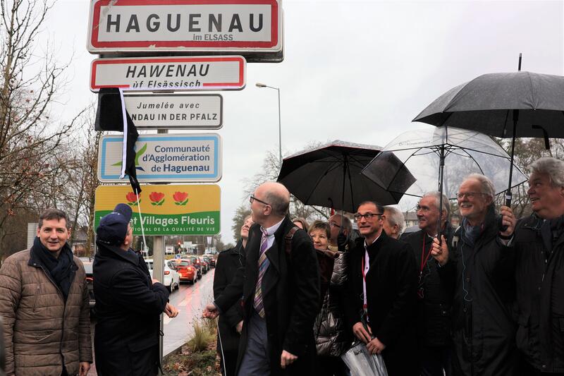 Gemeinsam enth&uuml;llten die Vertreterinnen und Vertreter aus Haguenau und Landau eine Hinweistafel auf die St&auml;dtepartnerschaft am Haguenauer Ortseingang.
