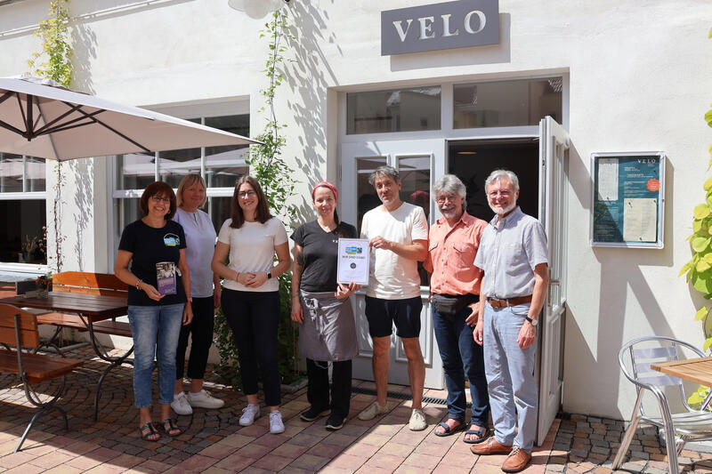 Bei der &Uuml;bergabe der Fairtrade-Urkunde (v.l.n.r.): Annette Liebel (Lokale Agenda/st&auml;dtisches Umweltamt), Heike Hohlfeld (Kaufland), Beigeordnete Lena D&uuml;rphold, Tanja und Philipp Hirsch (VELO), Pfarrer J&uuml;rgen Leonhard und Pfarrer i. R. Dieter Weber. 