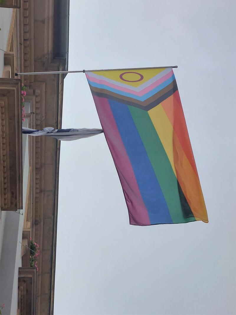 Am Landauer Rathaus hing am Internationalen Tag gegen Homo-, Bi-, Inter- und Transfeindlichkeit die sogenannte Progress-Pride-Flagge als Zeichen f&uuml;r Vielfalt und Toleranz.