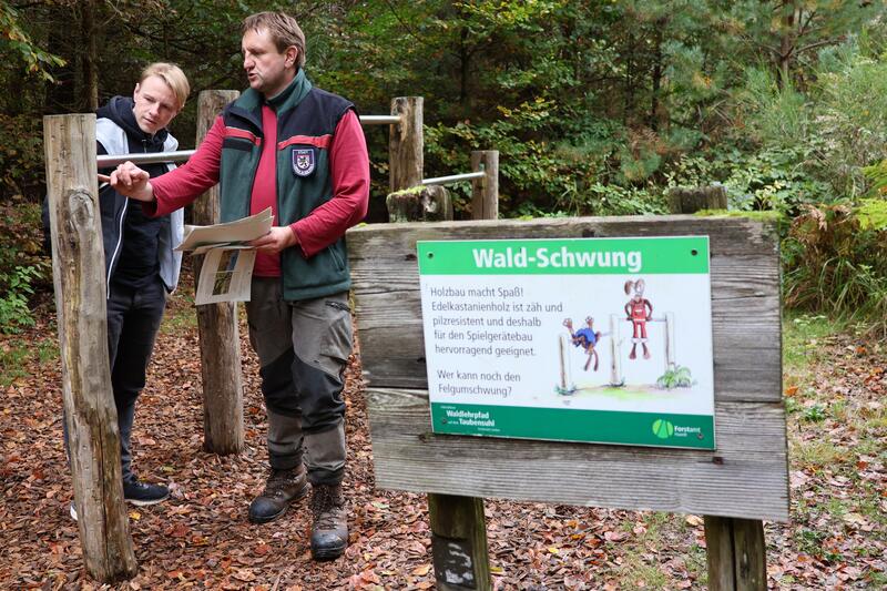 Forstwirt Stefan G&uuml;nther zeigt B&uuml;rgermeister Lukas Hartmann die Station &raquo;Wald-Schwung&laquo;.
