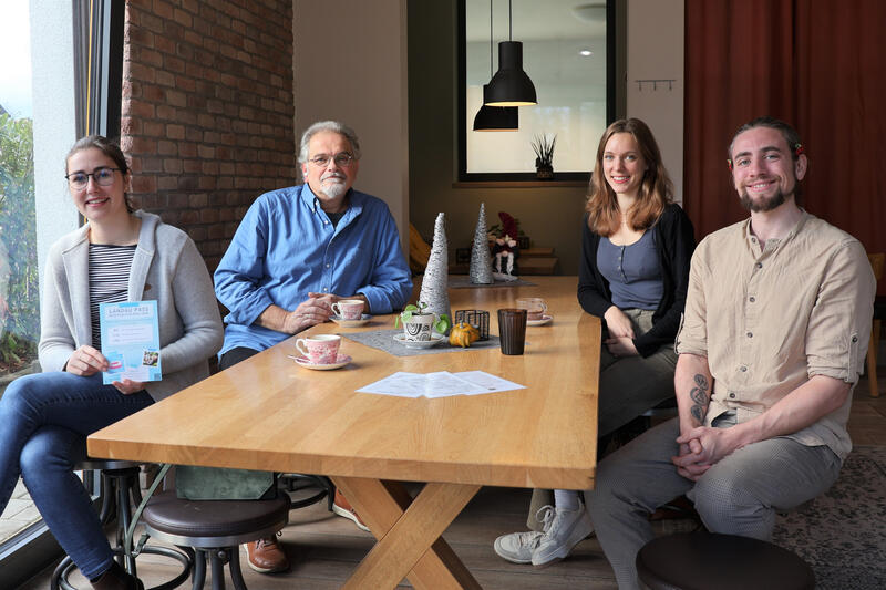 Beigeordnete Lena D&uuml;rphold (v.l.n.r.), Stadtjugendpfleger Arno Sch&ouml;nh&ouml;fer und Juf&ouml;-Mitarbeiterin Dominique Heinekamp freuen sich, dass Nils Sch&uuml;&szlig;ler und sein Caf&eacute; zur Krummbeere in der Thomas-Nast-Stra&szlig;e jetzt neu beim LandauPass dabei sind. 