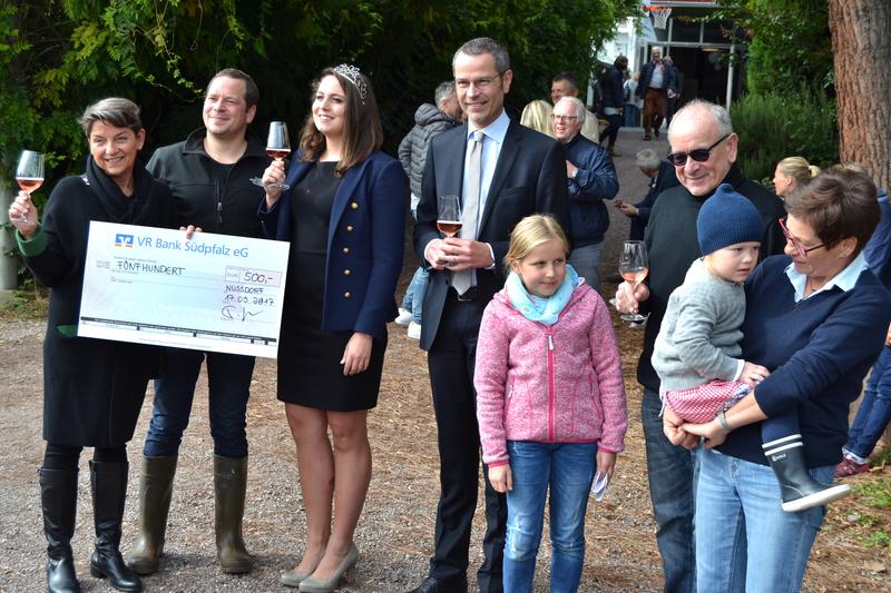 B&uuml;rgermeister Dr. Maximilian Ingenthron (4.v.l.), Weinprinzessin Lilli I. (3.v.l.) und Familie Pfaffmann &uuml;berreichten den Spendenscheck jetzt gemeinsam an Dr. Christine Altst&ouml;tter-Gleich (l.), Vorsitzende des Tr&auml;gervereins des Frauenhauses.