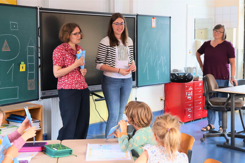 In der Grundschule Arzheim haben Schuldezernentin Lena D&uuml;rphold (Mitte) und Bibliotheksleiterin Amelie L&ouml;hlein (links) die Schult&uuml;ten pers&ouml;nlich an die Erstkl&auml;sslerinnen und Erstkl&auml;ssler von Schulleiterin Ute Antoni &uuml;berreicht. 