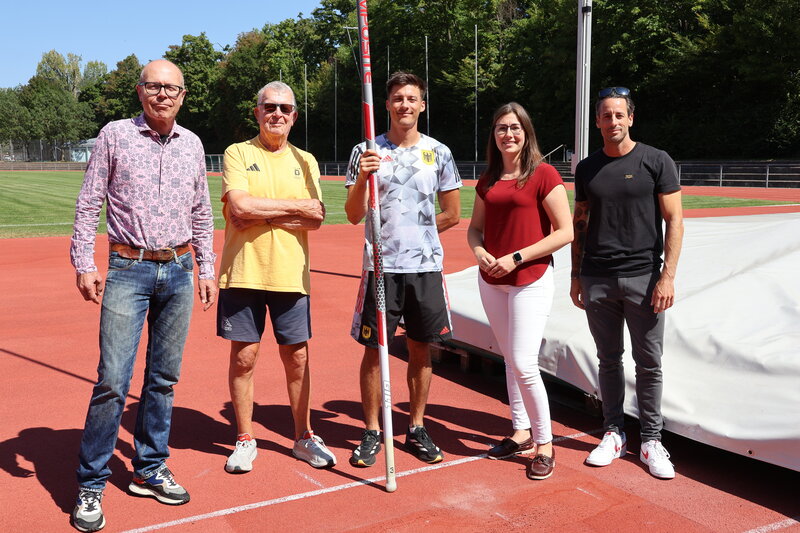Oberb&uuml;rgermeister Dominik Gei&szlig;ler (links) und Sportdezernentin Lena D&uuml;rphold &uuml;berbringen an Oleg Zernikel (Mitte) die Gl&uuml;ckw&uuml;nsche der Stadt Landau. Trainer Jochen Wetter (2. von links) und Dennis Schober geh&ouml;ren zum Team. Bei den Weltmeisterschaften in T
