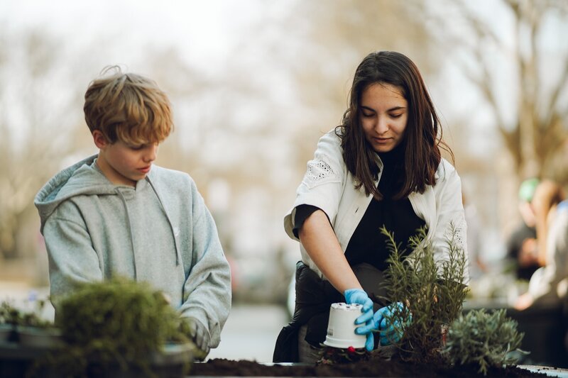 Aus Grau wird Gr&uuml;n: Landauer Sch&uuml;lerinnen und Sch&uuml;ler bepflanzen Zufahrtsschutzelemente in der Landauer Innenstadt. 