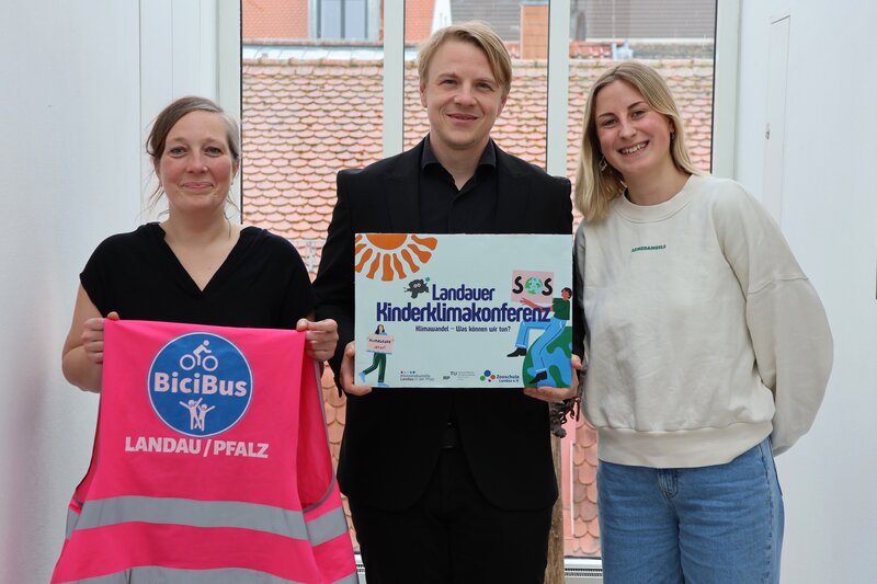 B&uuml;rgermeister Lukas Hartmann sowie Jenni Follmann (l.) und Pia Maas von der st&auml;dtischen Klimastabsstelle freuen sich &uuml;ber die doppelte Klima-Auszeichnung f&uuml;r Landau.