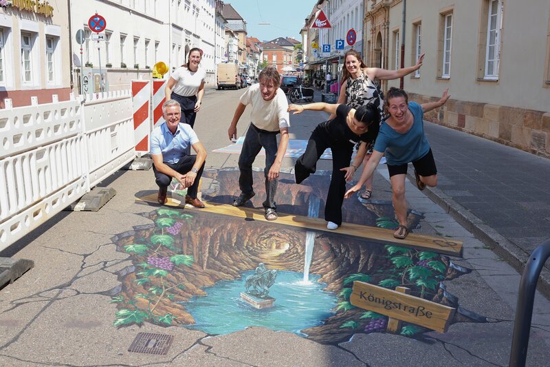 Martin Messemer, Leiter der Wirtschaftsf&ouml;rderung der Stadt Landau (v. l.), Lena D&uuml;rphold, Gesch&auml;ftsf&uuml;hrerin der Stadtholding Landau (h. l.), Manfred Stader, Stra&szlig;enk&uuml;nstler (2. v. l.), Nour Abboud, Vertreterin von Ralph Leibbrand, dem Ideengeber des Proje