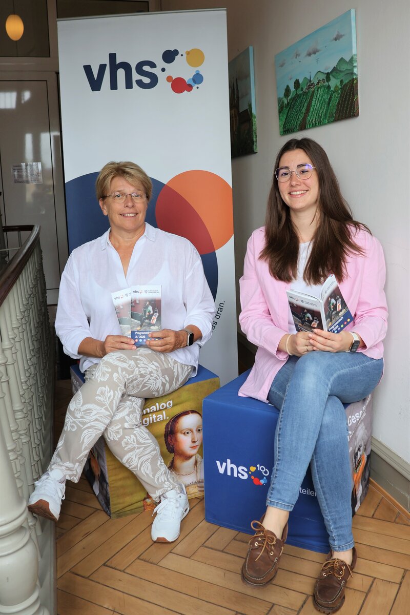 Die Leiterin der VHS Landau, Sigrid Gensheimer (links), und die Vorsitzende der VHS Landau und Beigeordnete Lena D&uuml;rphold (rechts) pr&auml;sentieren das neue Herbstprogramm 2026 der VHS Landau. 