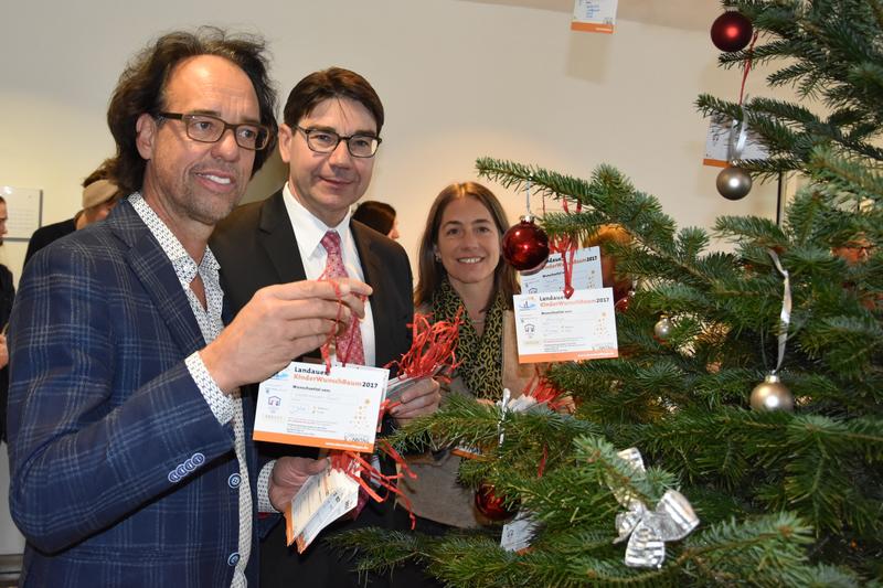 Kabarettist Christoph Sonntag, Oberb&uuml;rgermeister Thomas Hirsch und Susanne Burgd&ouml;rfer vom Haus der Familie (v.l.n.r.) beim Aufstellen des diesj&auml;hrigen Landauer Kinderwunschbaums. 