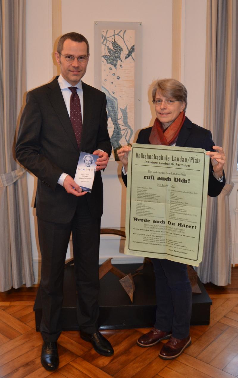 B&uuml;rgermeister Dr. Maximilian Ingenthron und VHS-Leiterin Sigrid Gensheimer mit dem neuen VHS-Programm f&uuml;r das erste Halbjahr 2017 und einem VHS-Plakat aus dem Jahr 1947.