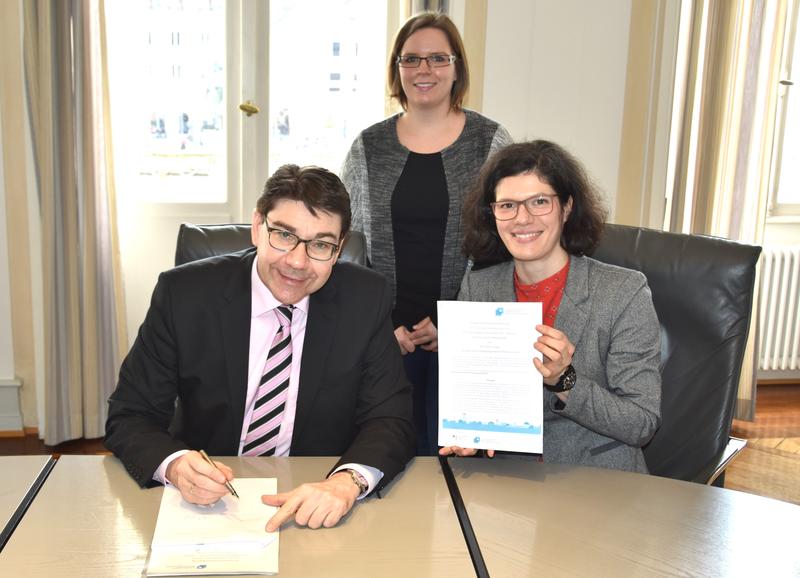 Oberb&uuml;rgermeister Thomas Hirsch gemeinsam mit Bildungskoordinatorin Kim Ingledue und Dr. Franziska Ziegelmeyer, Beraterin der Transferagentur, bei der Unterzeichnung der Kooperationsvereinbarung. 