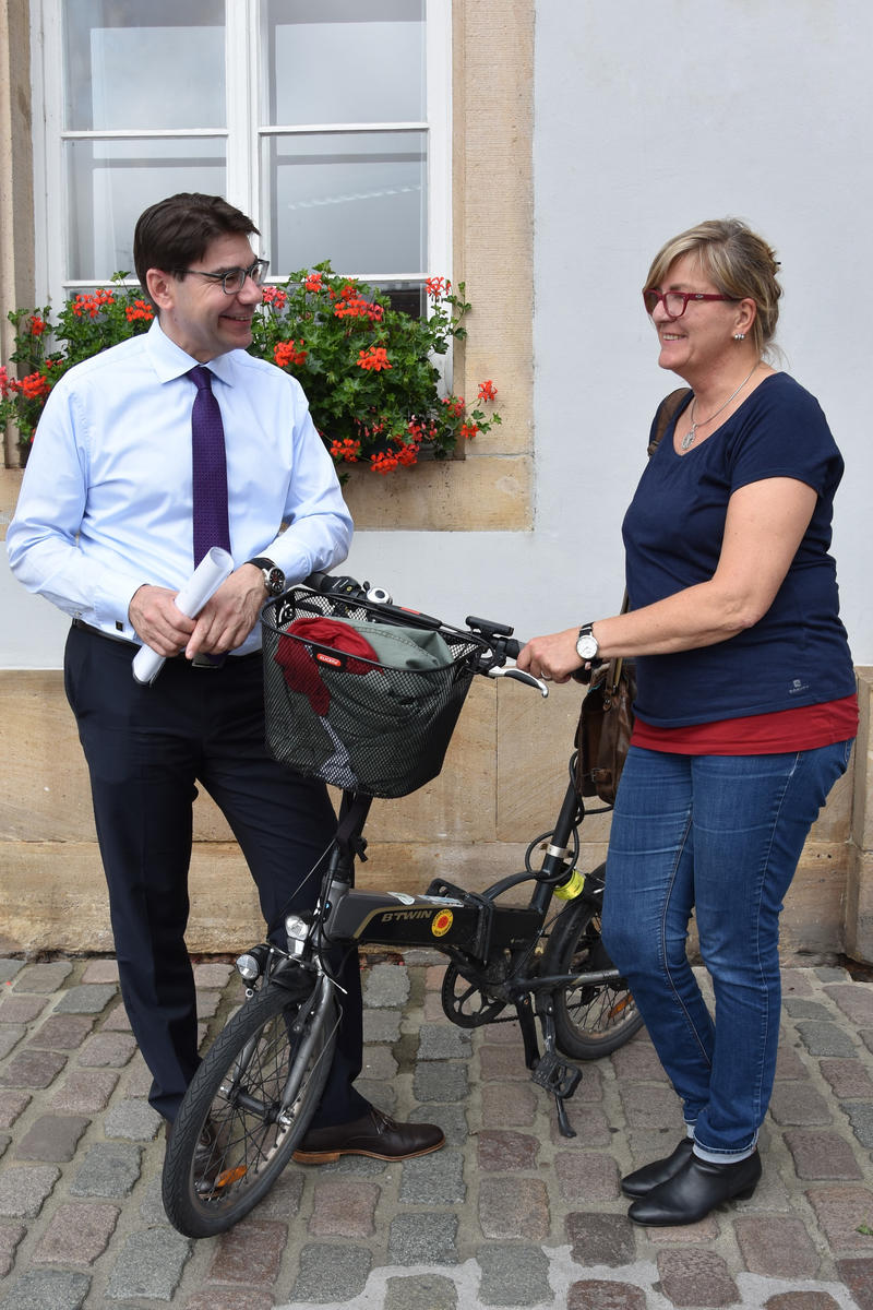 Streetworkerin Katrin Marquardt und Oberb&uuml;rgermeister Thomas Hirsch mit Marquardts Markenzeichen, dem schwarzen Elektro-Klapprad. 