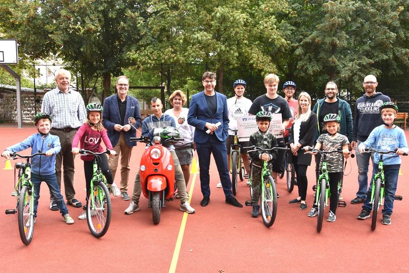 Oberb&uuml;rgermeister Thomas Hirsch (M.), Landtagsabgeordneter Wolfgang Schwarz (2.v.l.) und Schulleiterin Angelika B&uuml;hler (3.v.l.) gemeinsam mit Lehrern und Mitgliedern des Mofa-Kurses und der Fahrradwerkstatt bei der kleinen Feierstunde auf dem Schulhof der