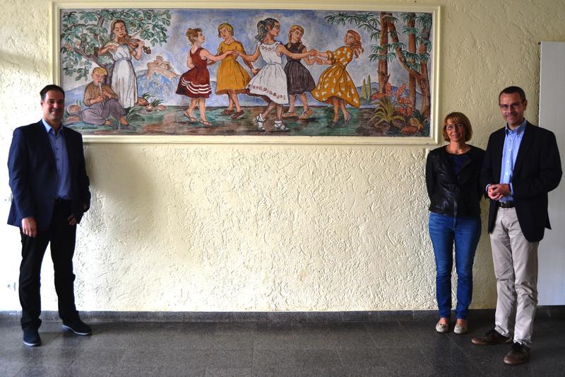 B&uuml;rgermeister und Kulturdezernent Dr. Maximilian Ingenthron (r.) gemeinsam mit der Schulleiterin der Grundschule Wollmesheimer H&ouml;he, B&auml;rbel Schwenk-Kories, und dem Werkleiter des st&auml;dtischen Geb&auml;udemanagements, Michael G&ouml;tz (l.), vor dem wiederentdeckten 