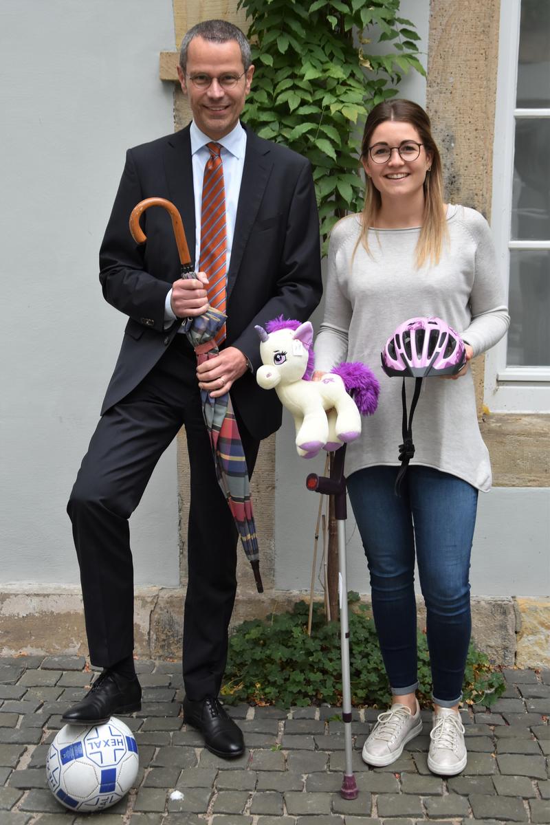 B&uuml;rgermeister Dr. Maximilian Ingenthron und Angelina Wind, Leiterin des B&uuml;rgerb&uuml;ros, mit einer Auswahl der Artikel, die bei der j&uuml;ngsten Online-Versteigerung der Stadt Landau die Besitzerin bzw. den Besitzer gewechselt haben. 