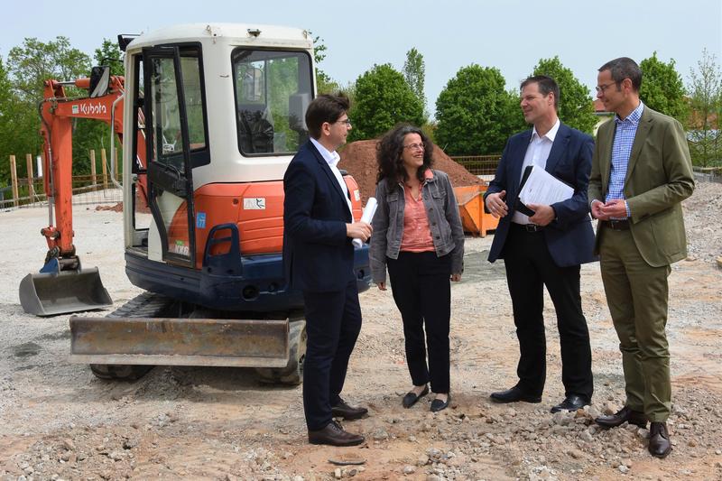 Vorfreude auf den neuen Bau: Oberb&uuml;rgermeister Thomas Hirsch, Schulleiterin Andrea Moser, GML-Werkleiter Michael G&ouml;tz und B&uuml;rgermeister Dr. Maximilian Ingenthron (v.l.n.r.) beim Vor-Ort-Termin auf dem Gel&auml;nde der Grundschule S&uuml;d. 