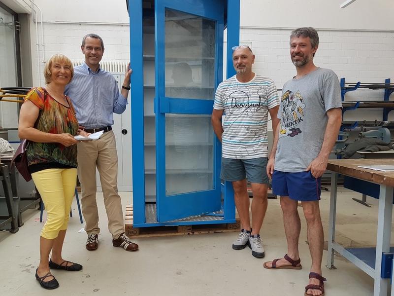 Initiatorin Monika Wehn, B&uuml;rgermeister Dr. Maximilian Ingenthron, BBS-Lehrer Christian Fr&ouml;de und Graffiti-K&uuml;nstler Till Heim (v.l.n.r.) beim Vor-Ort-Termin in der BBS mit der im Bau befindlichen B&uuml;cherboXX. Die fertige BoXX wird am Freitag, 16. August, im