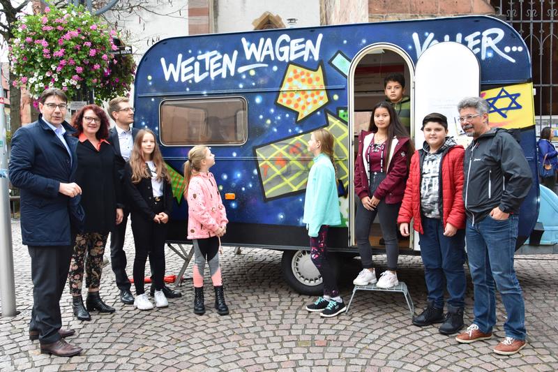 Ein Wohnwagen voller Kulturen und Religionen: Das ist der &raquo;Weltenwagen&laquo; von Dagmar Schuster-Rumpf (2.v.l.), hier bei der Vorstellung mit OB Thomas Hirsch (l.). 