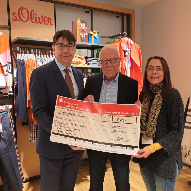OB Thomas Hirsch (l.) nahm im Landauer s. Oliver Store aus den H&auml;nden von Teamleiterin Alexandra Matheis und Gesch&auml;ftsf&uuml;hrer Peter Heuberger eine &raquo;T&uuml;tengeld&laquo;-Spende in H&ouml;he von 629 Euro entgegen.
