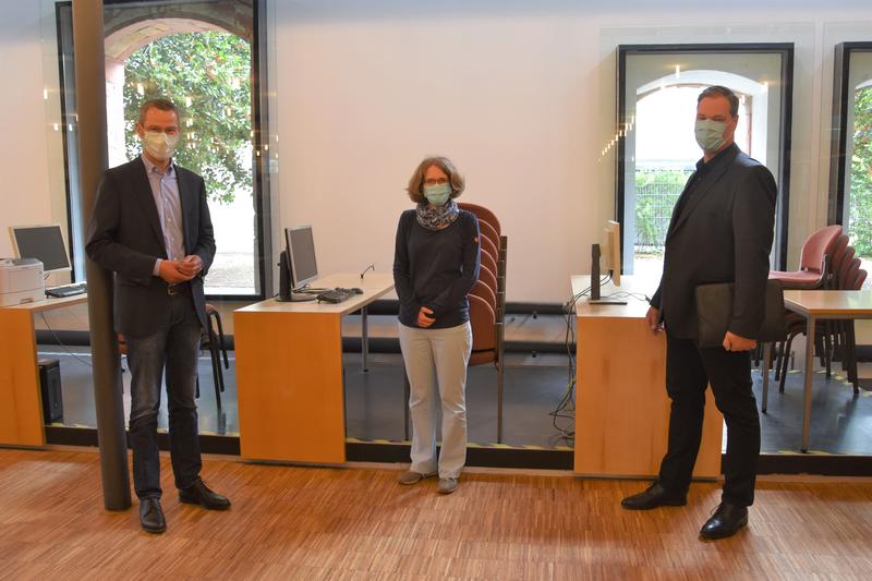 Mit Abstand und Mundschutz: B&uuml;rgermeister Dr. Maximilian Ingenthron, Einrichtungsleiterin Amelie L&ouml;hlein und GML-Werkleiter Michael G&ouml;tz (v.l.n.r.) in der frisch renovierten Stadtbibliothek. 