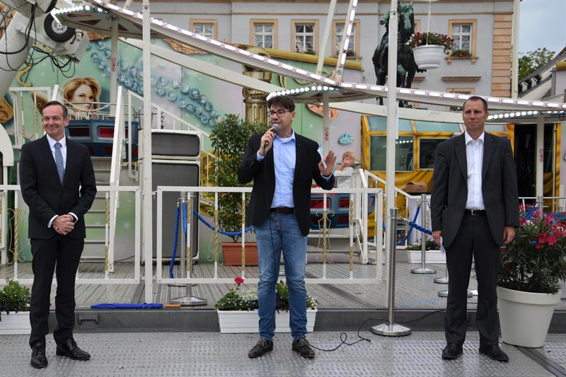 Gute Laune trotz schlechten Wetters: Wirtschaftsminister Dr. Volker Wissing, OB Thomas Hirsch und Tourismusdezernent Alexander Grassmann (v.l.n.r.) bei der Er&ouml;ffnung des Riesenrads auf dem Landauer Rathausplatz. 