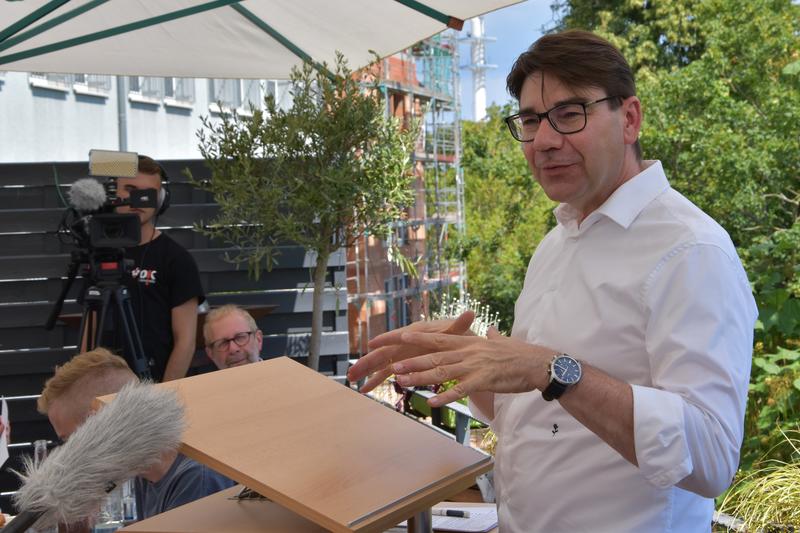 Landaus OB Hirsch beim Sommerpressegespr&auml;ch auf der Terrasse des Parkhotels. Im Hintergrund ist der im Bau befindliche Erweiterungsbau zu sehen. 