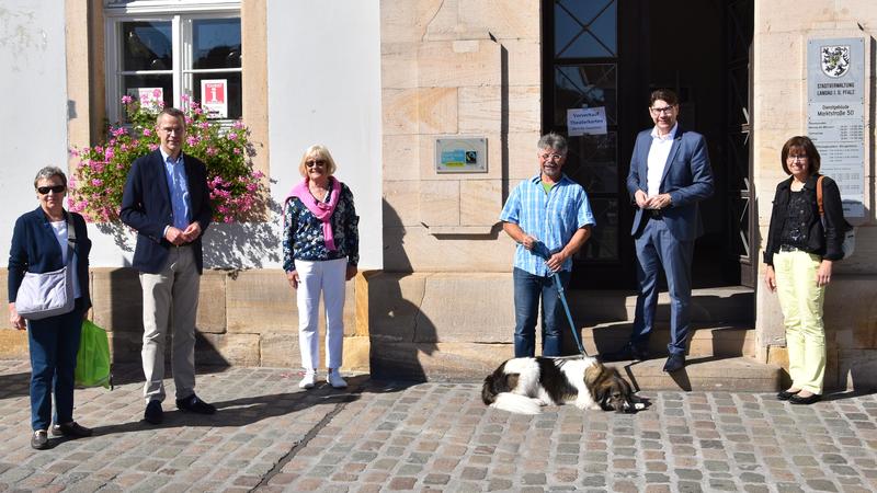 Freuen sich &uuml;ber das neue Schild am Landauer Rathaus: Jutta Br&auml;unling (Weltladen Landau), B&uuml;rgermeister Dr. Maximilian Ingenthron, Barbara Weyrauch (Weltladen Landau), Pfarrer J&uuml;rgen Leonhard mit vierbeiniger Begleiterin, Oberb&uuml;rgermeister Thomas Hirsch u