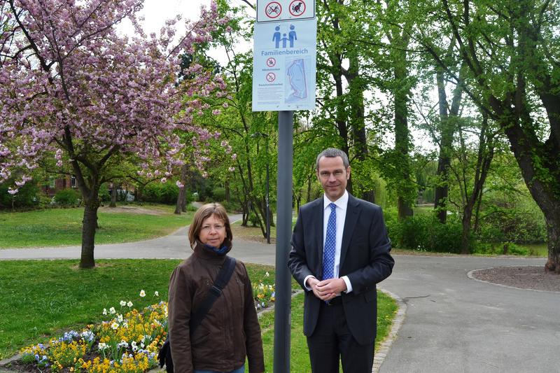 B&uuml;rgermeister und Ordnungsdezernent Dr. Maximilian Ingenthron und Sabine Klein, Leiterin der st&auml;dtischen Gr&uuml;nfl&auml;chenabteilung, pr&auml;sentieren die neuen Hinweisschilder f&uuml;r die Familienbereiche im Ostpark. Die Bem&uuml;hungen, das subjektive Sicherheitsgef&uuml;hl der