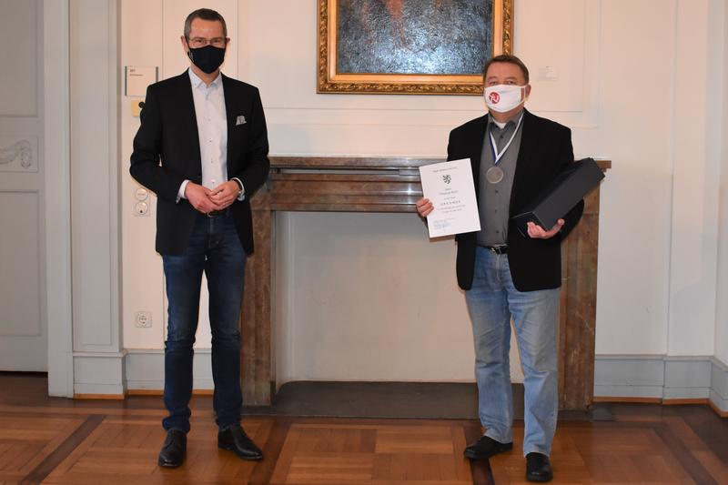 Stellvetretend f&uuml;r alle geehrten Sportlerinnen und Sportler &uuml;berreichte Sportdezernent Dr. Maximilian Ingenthron (links) die Stadtsporturkunde an Thomas Bohr vom Turnverein 1861 Landau.