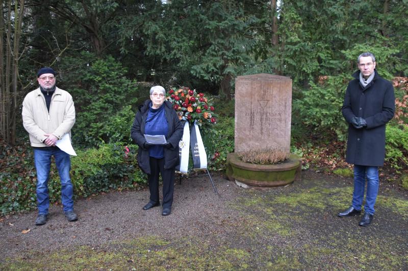 Hans-Martin Rieger und Elisabeth Morawietz vom Verein f&uuml;r Volksbildung und Jugendpflege sowie B&uuml;rgermeister Dr. Maximilian Ingenthron (v.l.n.r.) bei der Kranzniederlegung auf dem Landauer Hauptfriedhof.