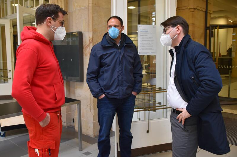 Simon Nichterlein, Vorsitzender der DLRG Landau, Sozialamtsleiter Jan-Marco Scherer, federf&uuml;hrend mit dem Aufbau der Teststation in der Jugendstil-Festhalle betraut, und OB Thomas Hirsch (v.l.n.r.) beim Vor-Ort-Austausch in der Jugendstil-Festhalle. 