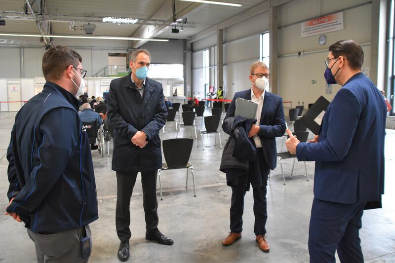  Impfkoordinator Bastian Dietrich, Staatssekret&auml;r Dr. Thomas Gebhart, Landrat Dietmar Seefeldt und OB Thomas Hirsch (v.l.n.r) beim Vor-Ort-Austausch im Impfzentrum Landau/S&uuml;dliche Weinstra&szlig;e.