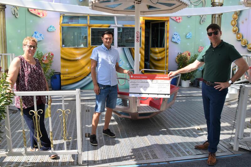 Marktmeisterin Sonja Brunner-Hagedorn, Schausteller Tobias G&ouml;bel und OB Thomas Hirsch (v.l.n.r.) bei der Spenden&uuml;bergabe f&uuml;r die Aktion &raquo;Weinregion f&uuml;r Weinregion - S&uuml;dpfalz hilft dem Ahrtal&laquo;. 