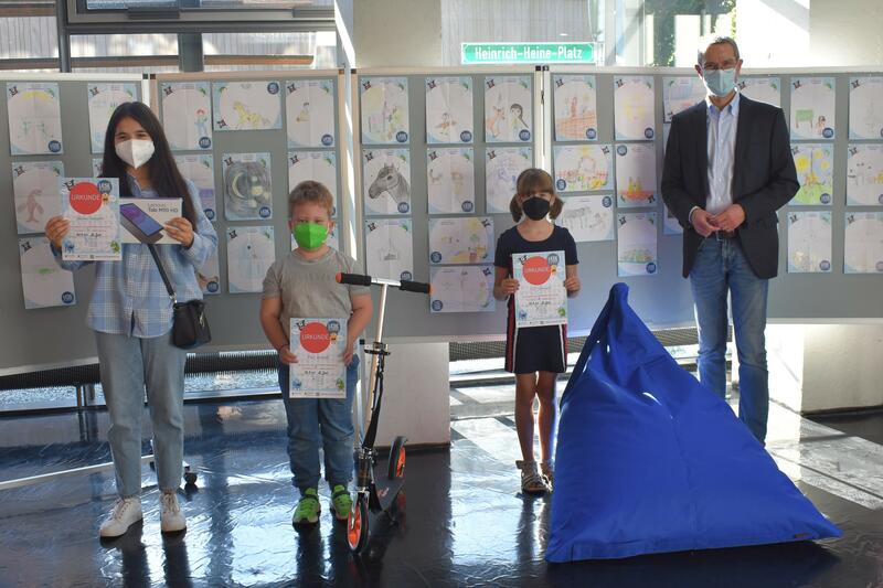 &raquo;Erlesene Preise&laquo; konnte Kulturdezernent Dr. Maximilian Ingenthron (rechts) an die Gewinnerinnen und den Gewinner des Lesesommers 2021 in Landau &uuml;berreichen: Sakine Hosseini (v.l.n.r.) bekam als Erstplatzierte ein Tablet, Paul Arneth kann ab sofort mit se