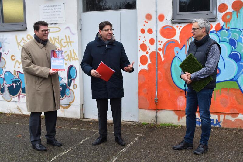 Bernd Jung, stellvertretender Vorstandsvorsitzender der Sparkasse S&uuml;dpfalz, und Oberb&uuml;rgermeister Thomas Hirsch &uuml;berreichen eine Spende f&uuml;r das neue Sportfeld an MSG-Schulleiter Jochen Flohn.  