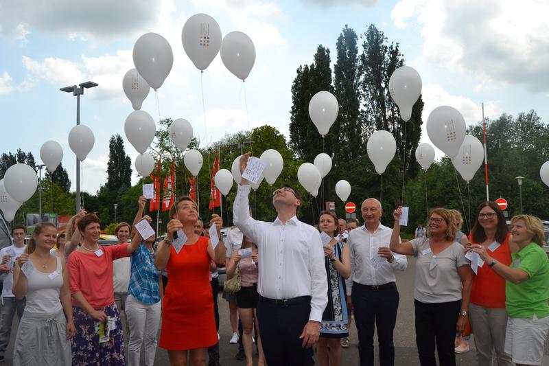 Luftballons steigen als Zeichen der Vielfalt in den noch blauen Himmel auf.
